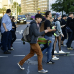 Crowd of men walking with devices