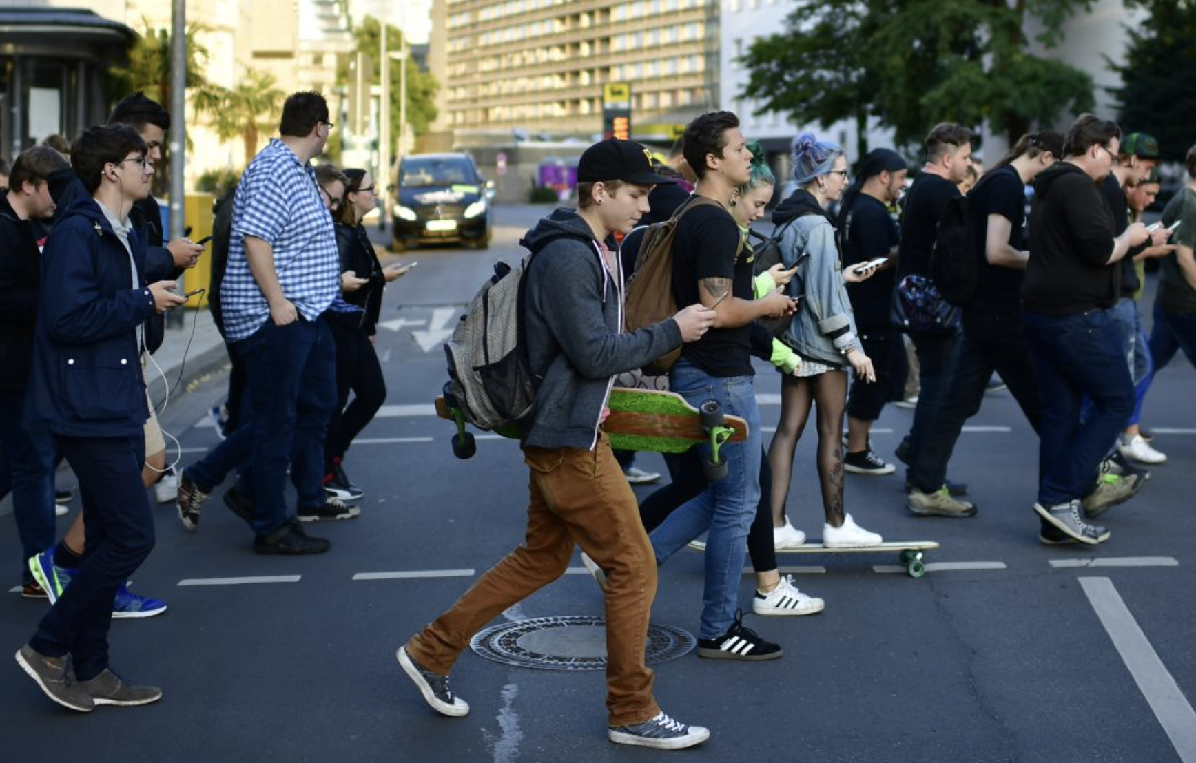 Crowd of men walking with devices