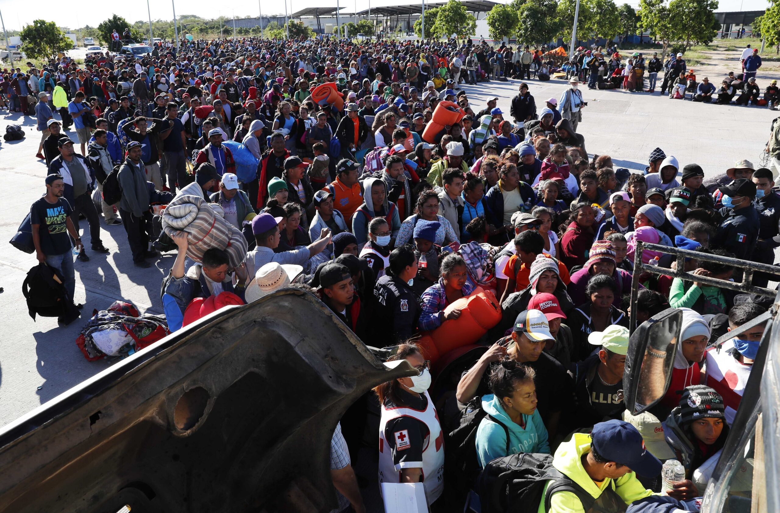 Migrants traveling with a caravan hoping to reach the US border, wait in line to board buses in La Concha, Mexico