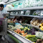 worker arranges produce in DC market