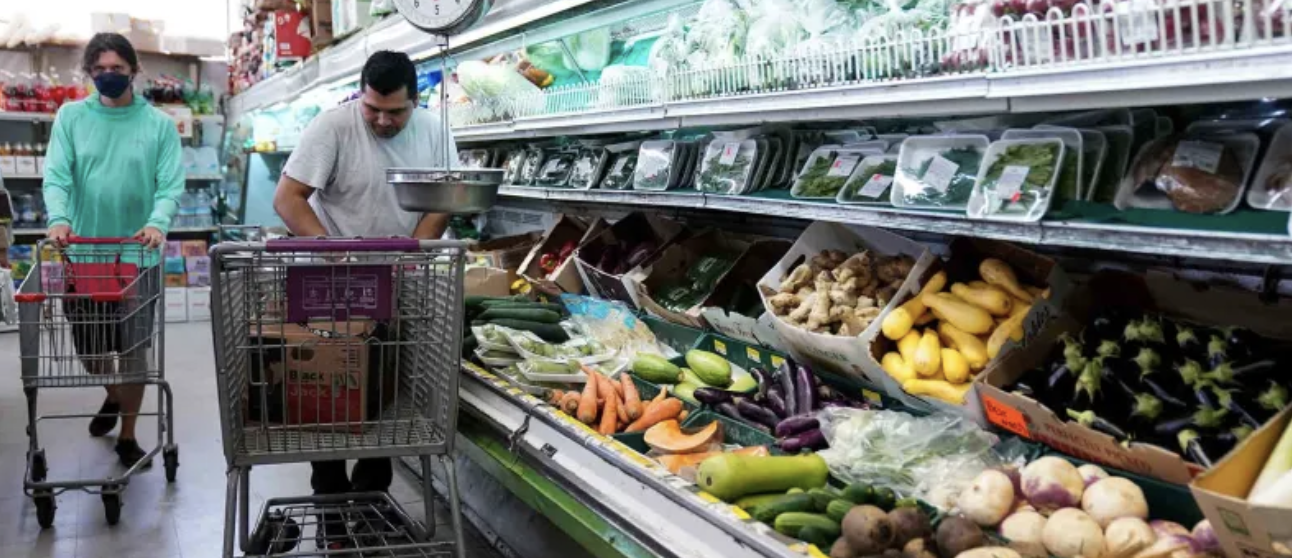 worker arranges produce in DC market