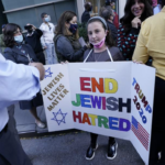 girl holding tri-fold poster Jewish & Trump supporter