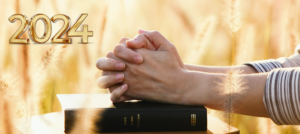 Praying for 2024 on Bible in Wheat Field