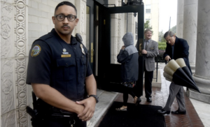 Off-Duty Police officer guards entrance to church - security