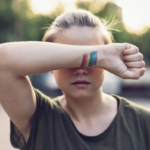 teen girl with wrist over eyes - rainbow on her wrist