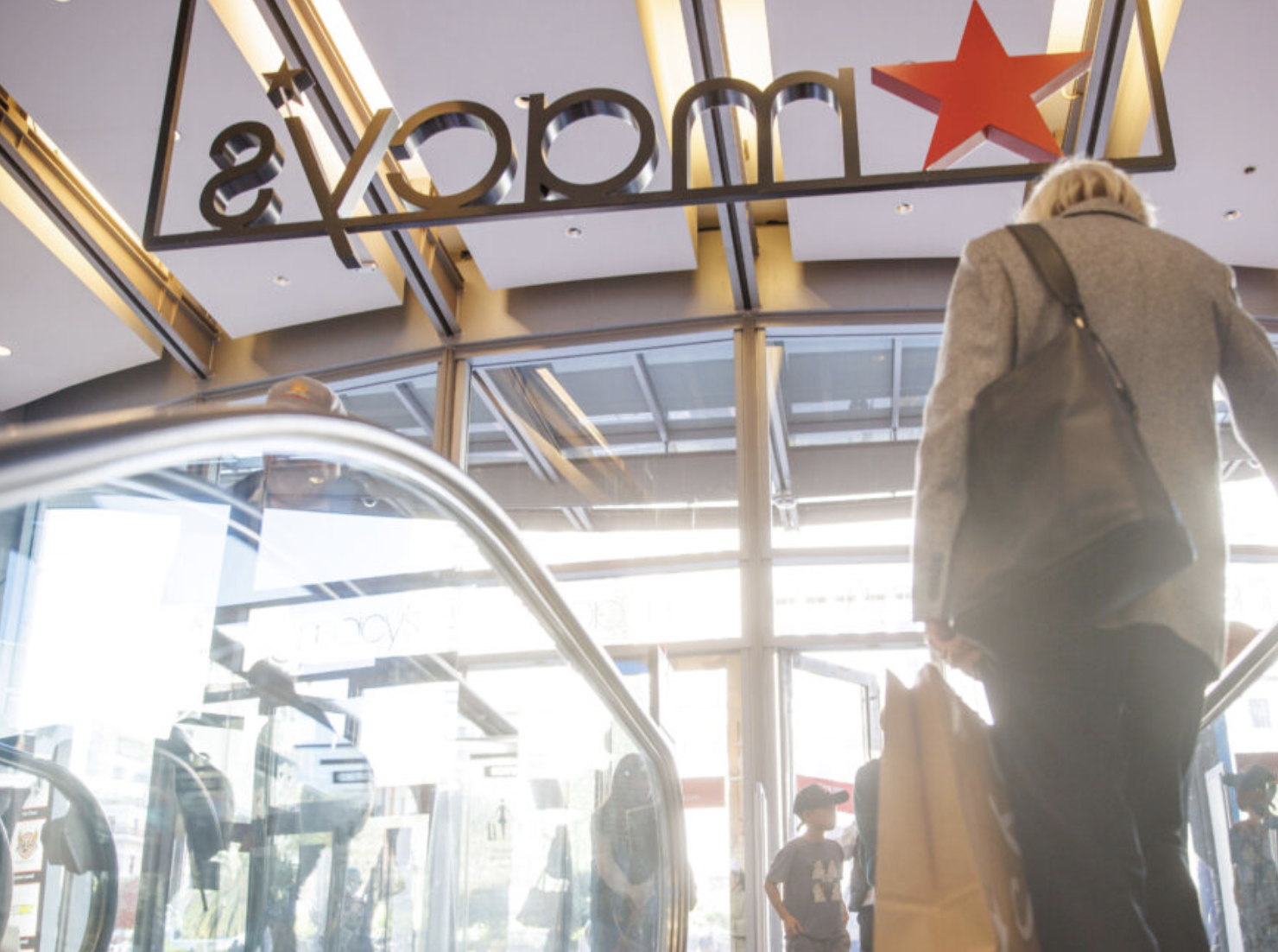 shopper at top of escalator in Macy's department store