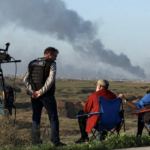 Journalists observe as smoke rises over Gaza