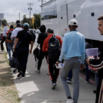 Illegal immigrants arrive by a bus at a transit center in San Diego