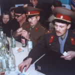 two Soviet Army soldiers at a liquor store counter to buy vodka