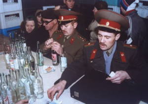 two Soviet Army soldiers at a liquor store counter to buy vodka