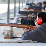Young men shooting rifles at gun range