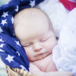 baby in basket wrapped in US flag