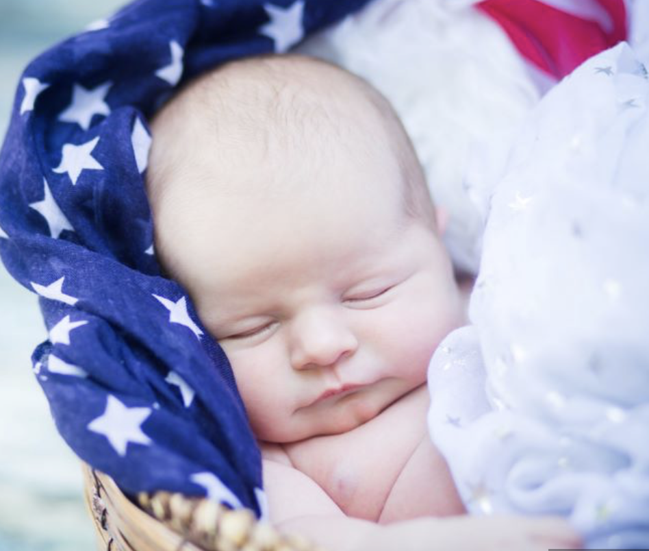 baby in basket wrapped in US flag