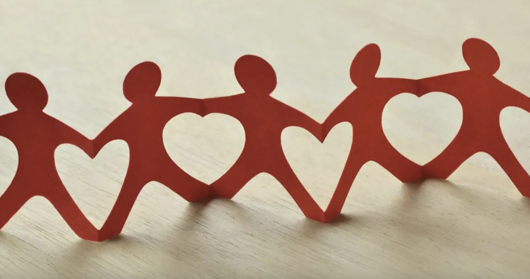 cut paper of men linked hands and feet to make cut-out hearts