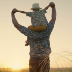 Father with son on his shoulders at sunset