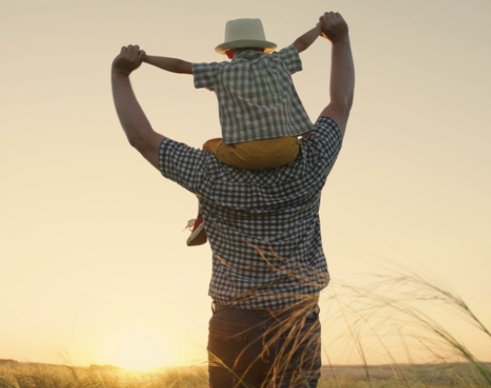 Father with son on his shoulders at sunset