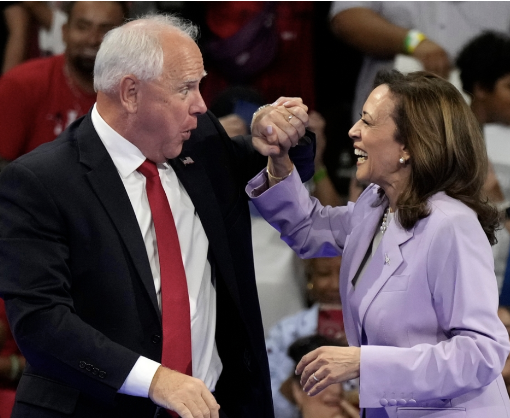 Kamala and Tim Walz with giddy smiles