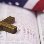 Open Bible, US Flag, wooden Cross