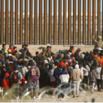 Migrants meet border patrol at US Border wall near El Paso, trying to enter the US