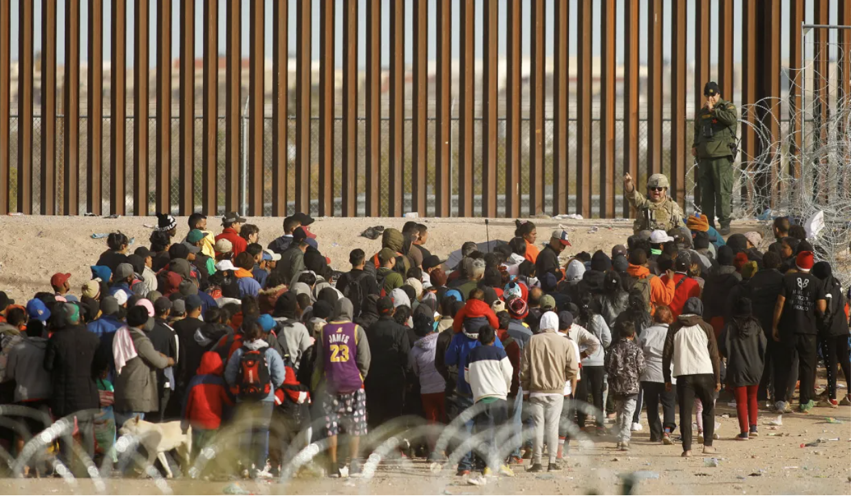 Migrants meet border patrol at US Border wall near El Paso, trying to enter the US