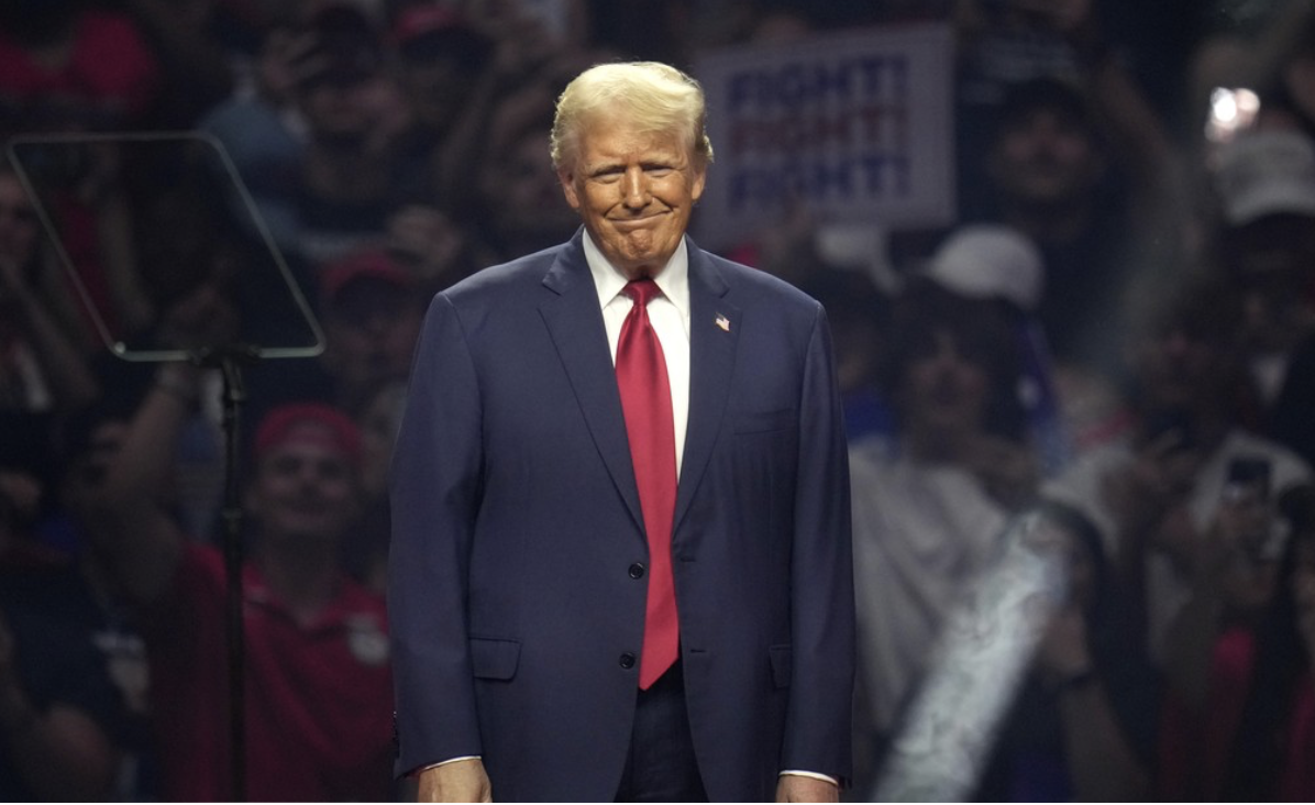 Smiling Trump stands on campaign stage