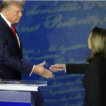 Trump on dias leans down to shake hands with VP Harris