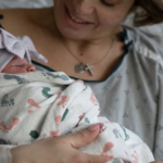 mother in birth center holds her newborn