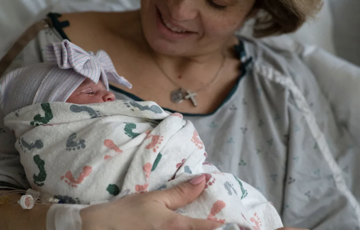 mother in birth center holds her newborn