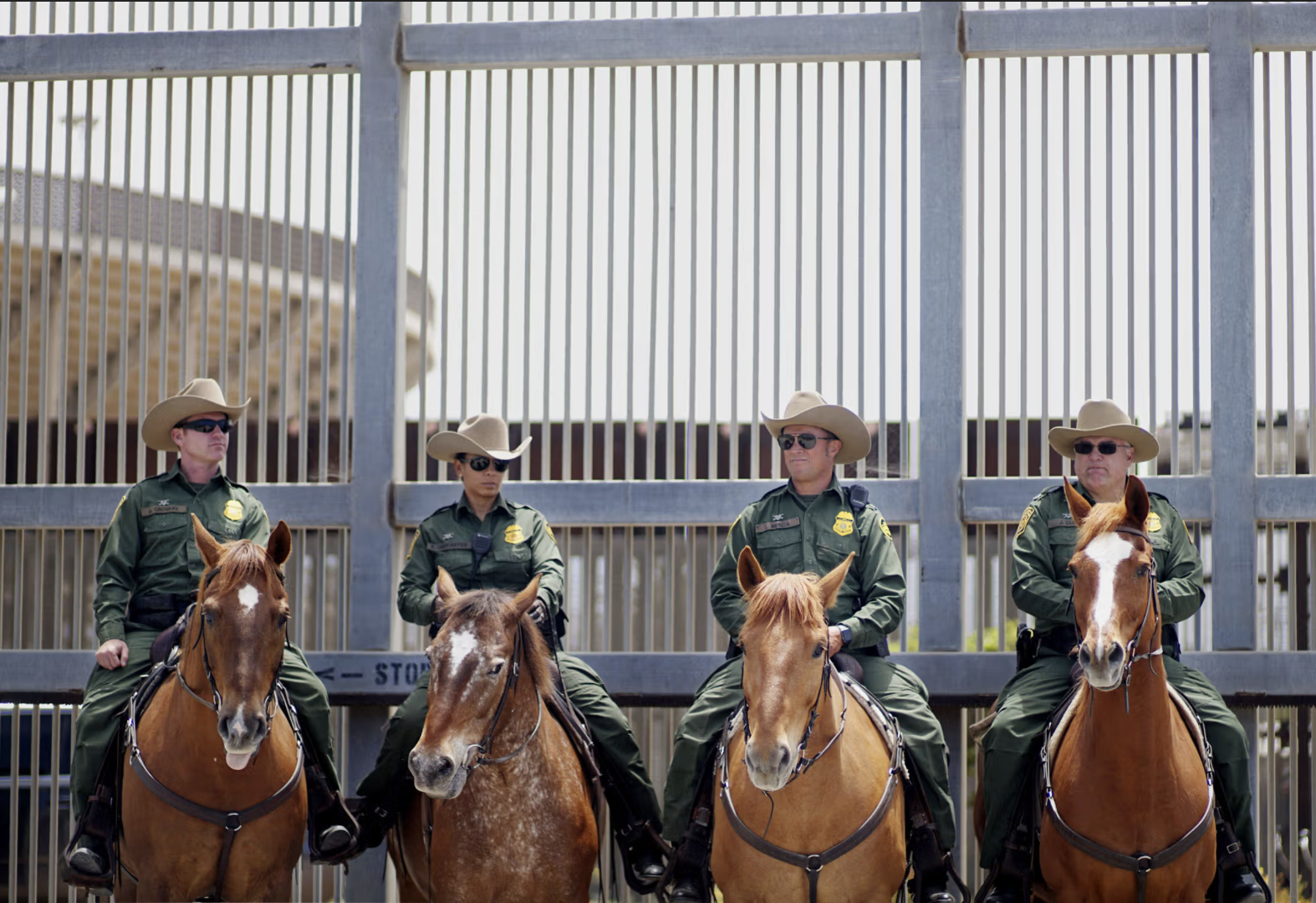 Armed mounted Border Patrol Agents in front of The Wall