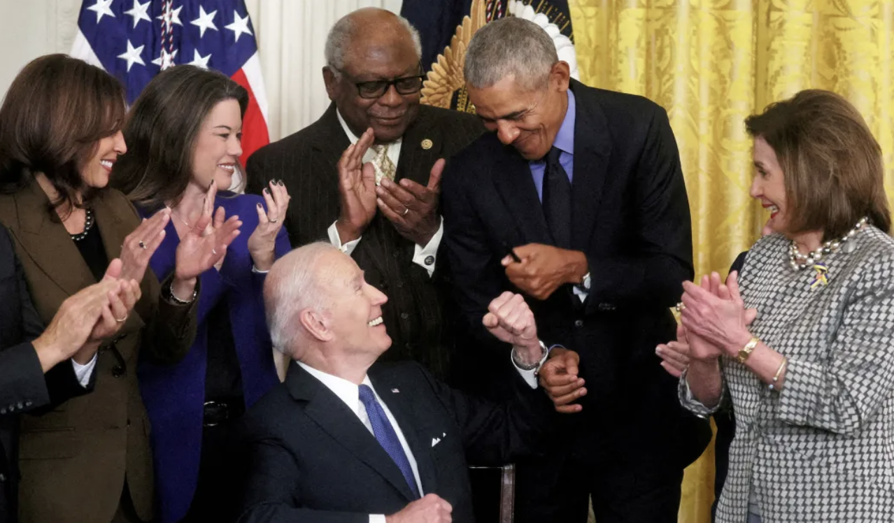 Biden Obama fist bump after signing legislation