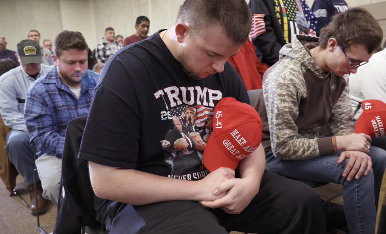 Young men with MAGA hats praying