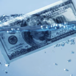 Hundred dollar bill sinking in tank of water