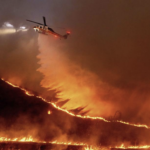 LA Fires - helicopter dumping water over flames