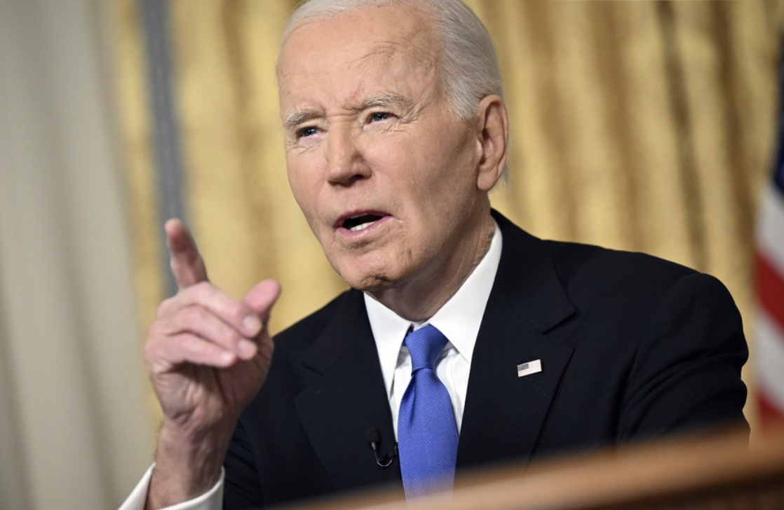 Biden sits and points in oval office