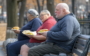 Obese People holding full plates on park bench.png