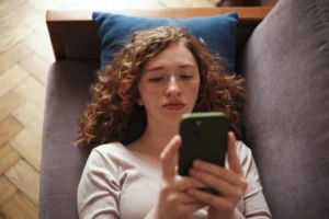 Gen Z-er bored on couch with phone