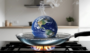 Globe of earth boiling on stovetop