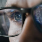 Human in glasses reflecting computer data