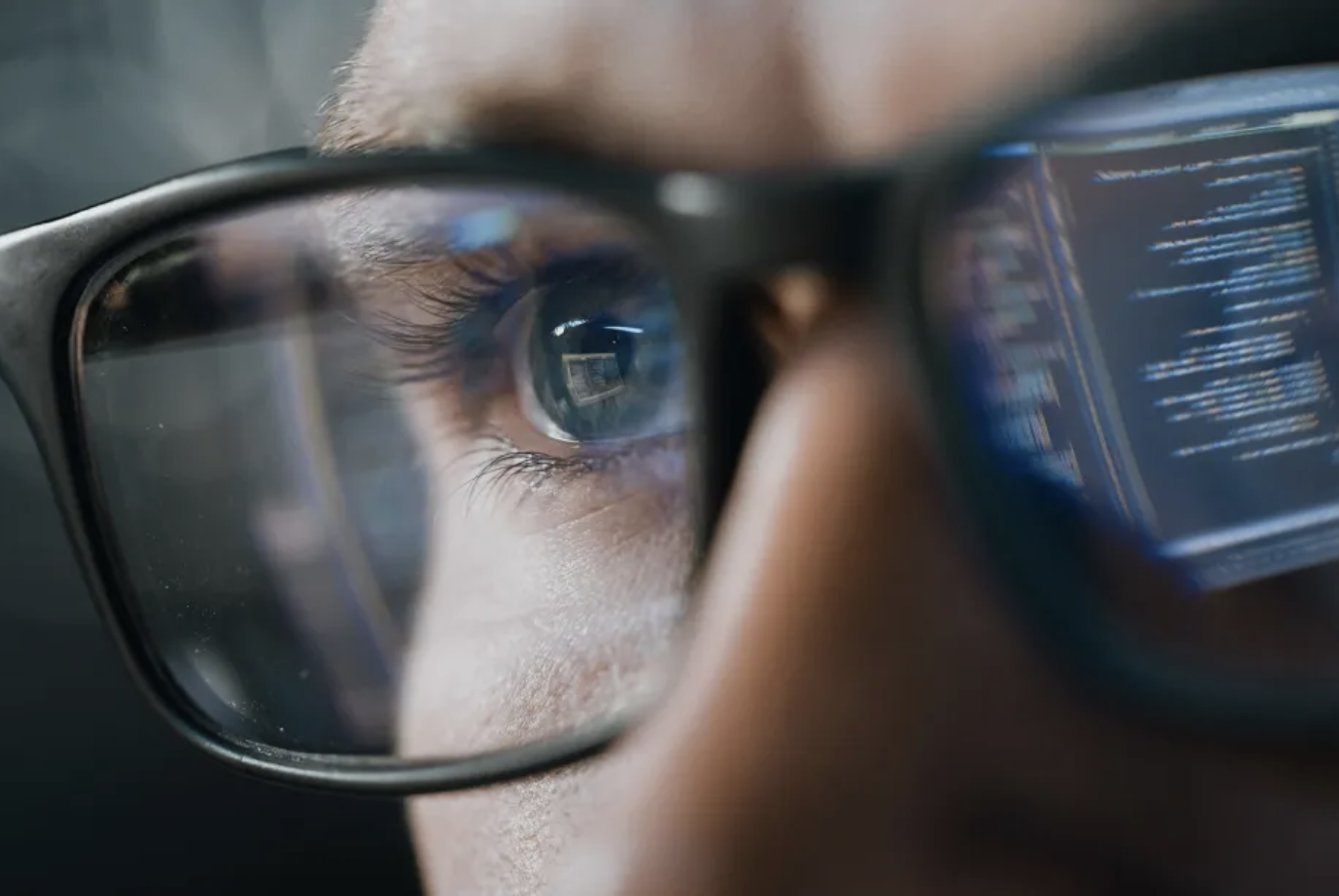 Human in glasses reflecting computer data