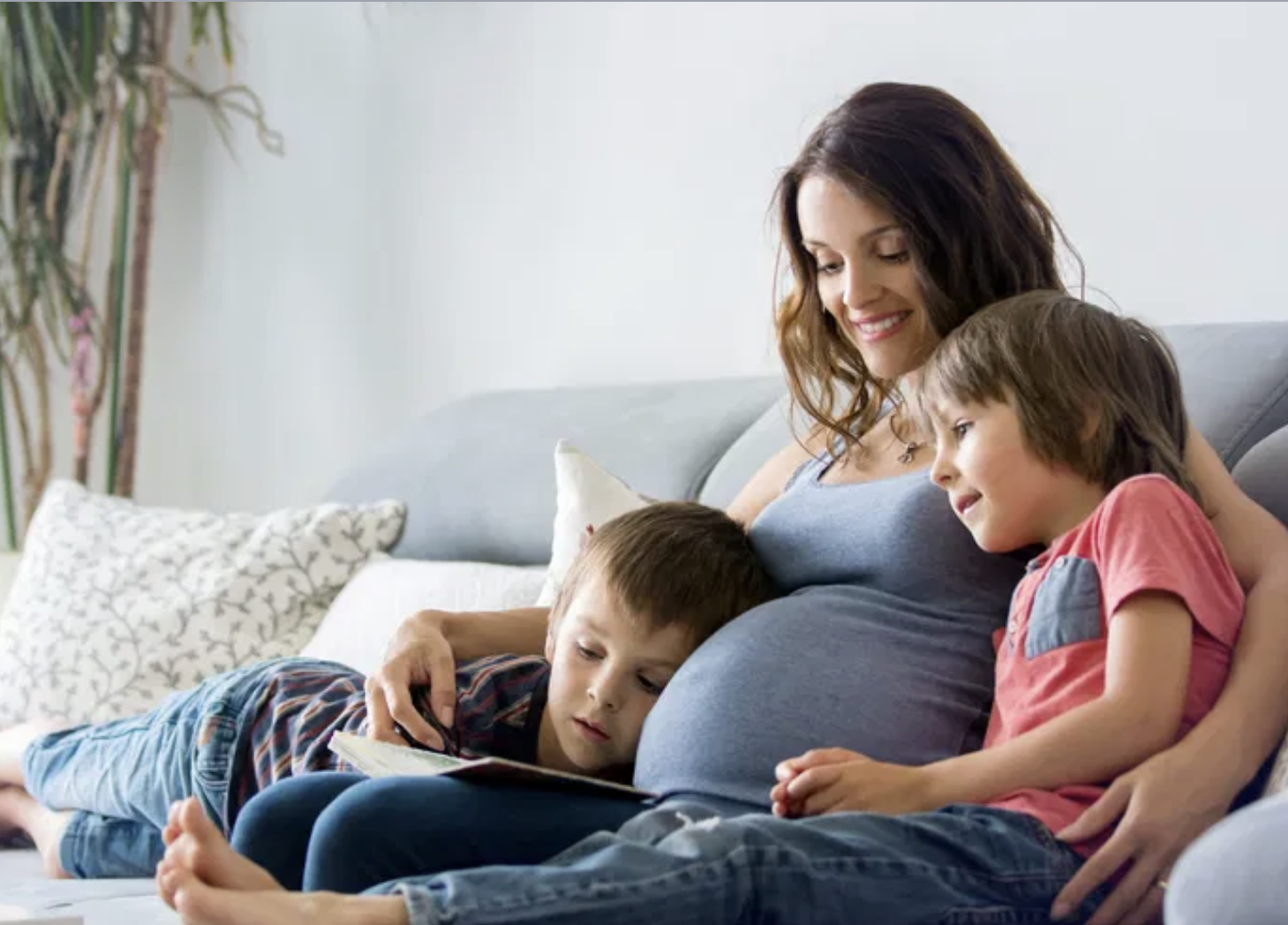 Pregnant Mom reads and cuddles with 2 sons