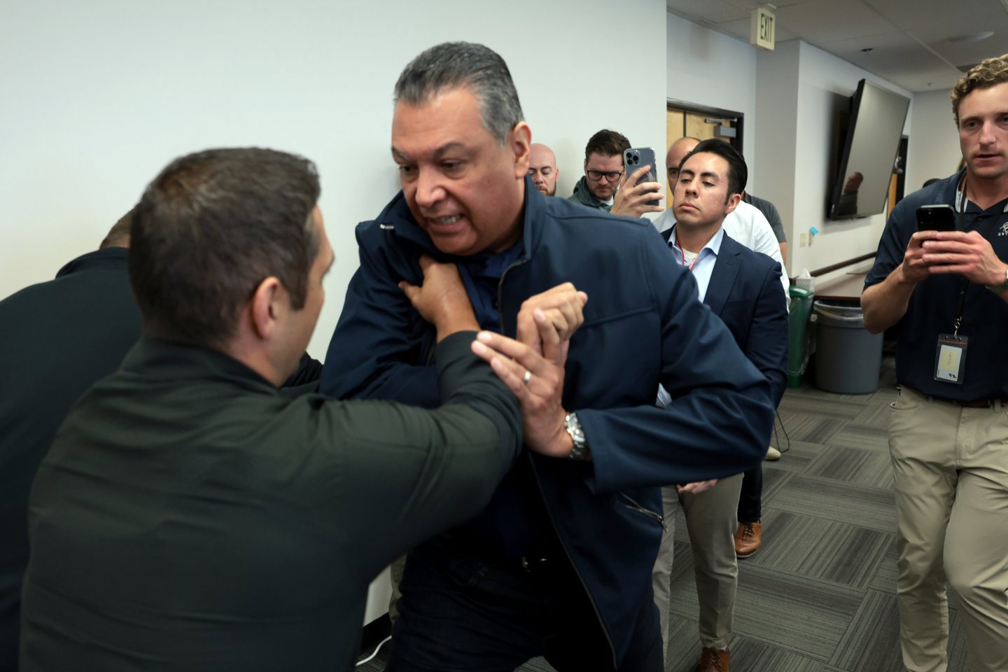 Alex Padilla is escorted out of press briefing by Secret Service.