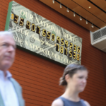 Pedestrians walk past the National Debt Clock in New York on June 4.