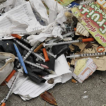 debris with used syringes in the street