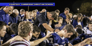 Cambridge Christian School football team praying