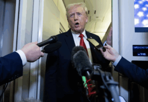 Trump speaks into microphones leaving airport