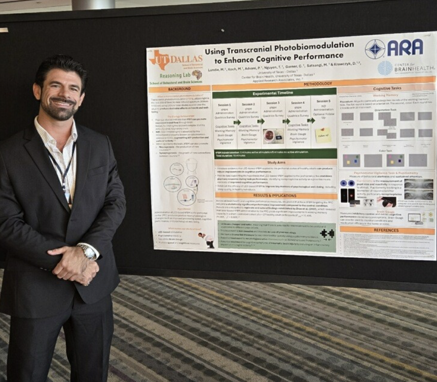 Michael Lundie MS’21, PhD’22 poses with a research poster