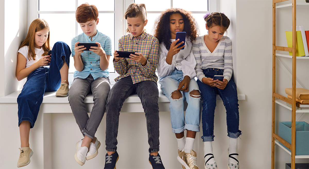 Children in a windowsill on their cellphones